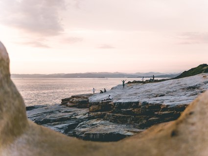 Pessoas aproveitando a praia nas pedras